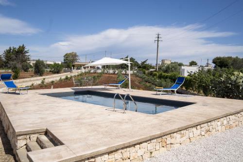 a swimming pool with two chairs and an umbrella at filìa ϕιλία in Serranova