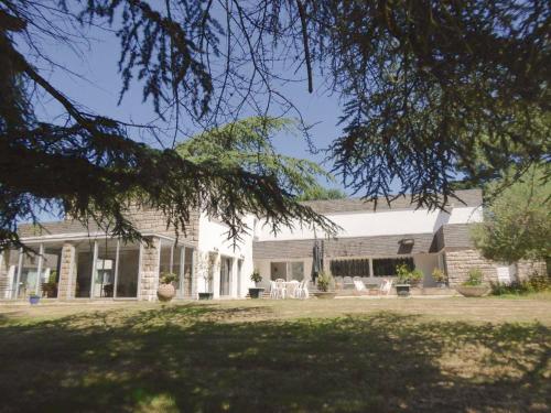 une maison en briques blanches avec des chaises et une cour dans l'établissement Domaine de la Chesnaie, à Josselin