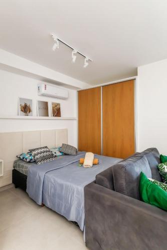 a bedroom with a large bed and a couch at Studio 2302 Independência 915 acad piscina in Juiz de Fora