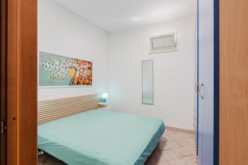 a bedroom with a bed and a painting on the wall at Villetta Elena in Alcamo
