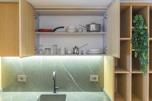 a kitchen with a sink and a shelf with dishes at CityZen - Boutique Studios in Achrafieh in Beirut