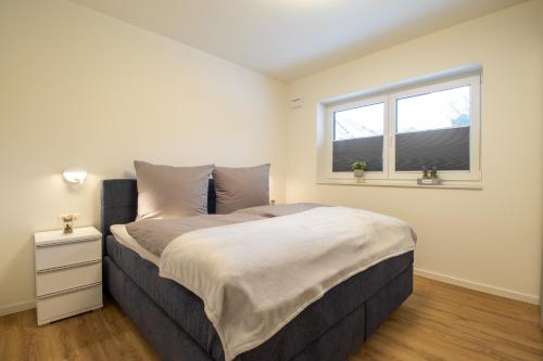 ein Schlafzimmer mit großem Bett und Fenster in der Unterkunft Herz von Kellenhusen 5 mit Terrasse und Sauna in Kellenhusen