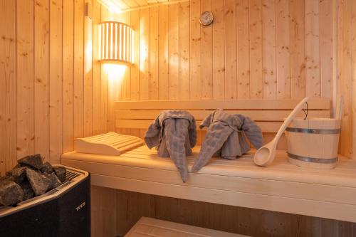 a wooden sauna with two mitts on a bench at Penthouse 18 - mit Dachterrasse und Sauna in Dorum