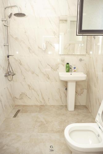 a white bathroom with a sink and a toilet at Hotel & Restaurant Frida in Gjakove