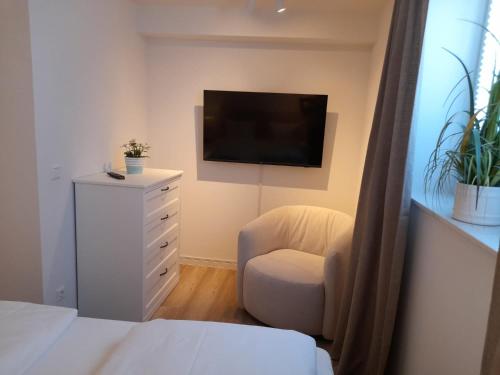 a bedroom with a bed and a chair and a television at Seestern 01 in Grömitz