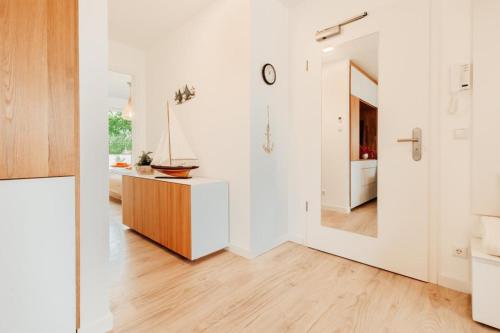 eine weiße Küche mit einer Holztheke und einem Flur in der Unterkunft Appartement Kranich - Moderne Ferienwohnung direkt am Schloss Ranzow! in Lohme