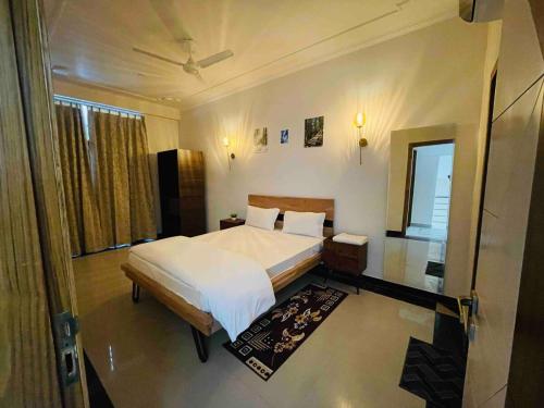 a bedroom with a large white bed and a window at Luxury 4BHK Villa Retreat by Akira homes in Jaipur