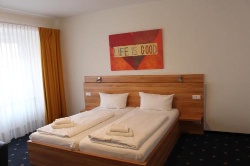 a bedroom with a large bed with a wooden headboard at Hotel Capri in Überlingen