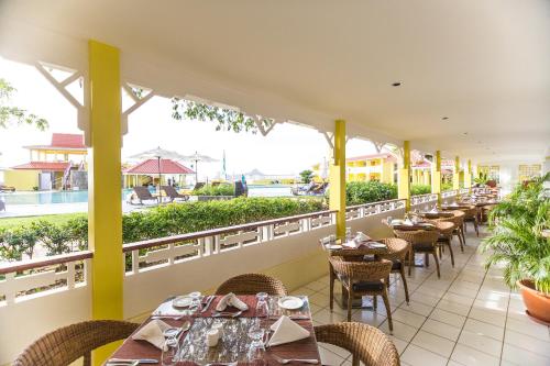 a restaurant with tables and chairs on a balcony at Starfish St Lucia - All Inclusive in Rodney Bay Village