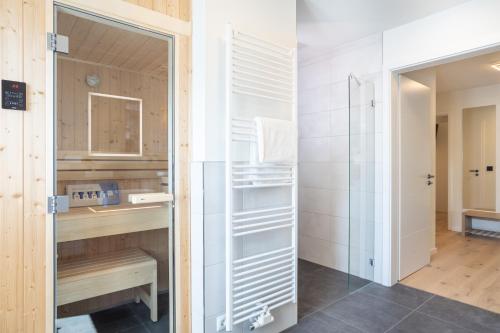ein Badezimmer mit Dusche, Waschbecken und Spiegel in der Unterkunft Villa Dornkamp 2 - Luxuriöse Ferienwohnung für 4 Personen inklusive Garten und Sauna in Timmendorfer Strand
