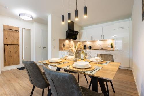 a kitchen and dining room with a wooden table and chairs at Dorumer Seestern - Ferienwohnung mit Terrasse und Sauna in Dorum