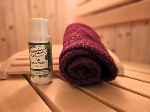 eine Flasche Desinfektionsmittel neben einem lila Handtuch in der Unterkunft Kellenhusen Tor 19 - mit Sauna und Garten, Hunde willkommen in Kellenhusen