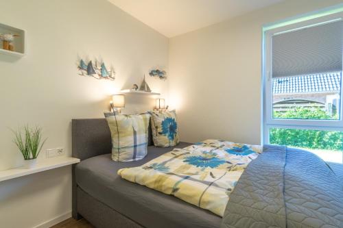 ein Schlafzimmer mit einem Bett und einem Fenster in der Unterkunft Kellenhusen Tor 19 - mit Sauna und Garten, Hunde willkommen in Kellenhusen
