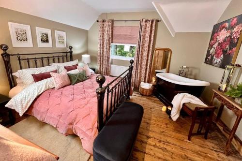 a bedroom with a bed and a tub and a sink at 6 Luxury home, near family park and Coffee Shop! in Merthyr Tydfil
