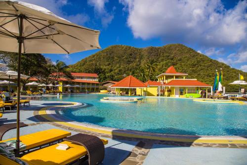 a pool at a resort with a mountain in the background at Starfish St Lucia - All Inclusive in Rodney Bay Village
