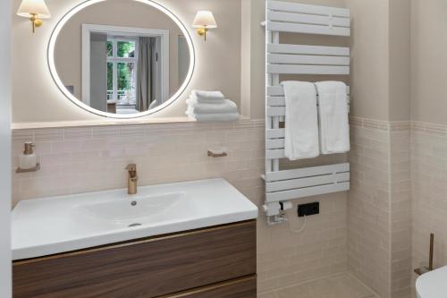 a bathroom with a sink and a mirror at Distillery Apartments in Lüneburg