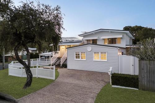 a white house with a white fence in a yard at BellaVita pet-friendly Oasis in Margate in Woody Point
