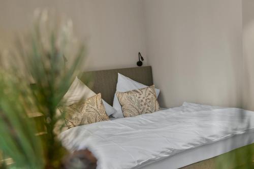 a bed with white sheets and pillows in a room at Distillery Apartments in Lüneburg
