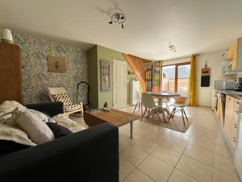 un soggiorno con un divano e un tavolo di Le cottage de Mag a Cerences