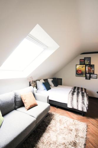 a attic bedroom with a bed and a couch at Getaway Studios Brussels Airport in Zaventem