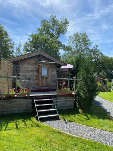 a log cabin with stairs leading up to it at Roulottes des Combrailles in Saint-Pardoux