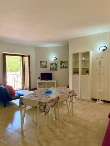 a living room with a table and chairs in a room at Mickey House, Maratea alta e fresco relax in Maratea