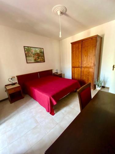 a bedroom with a red bed and a table at Mickey House, Maratea alta e fresco relax in Maratea