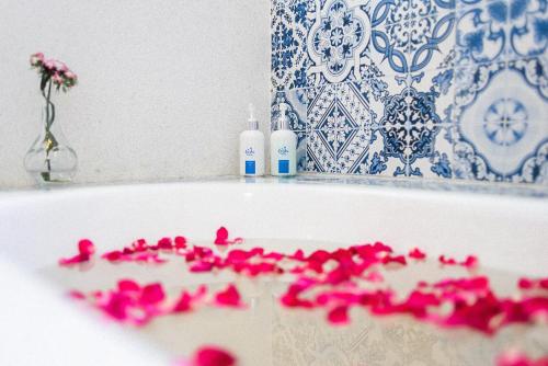 a bath tub filled with pink flowers in a bathroom at Costa Village Bangsaray in Bang Sare