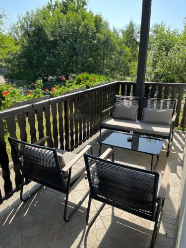 two benches and a table on a balcony at Aurora Plitvice in Smoljanac