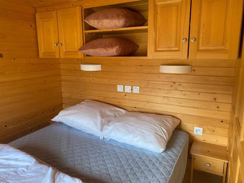 a bedroom with a bed with two pillows on it at Roulottes des Combrailles in Saint-Pardoux