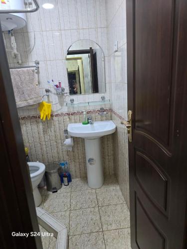 a bathroom with a sink and a toilet and a mirror at Festival Suites Ferghana in Fergana