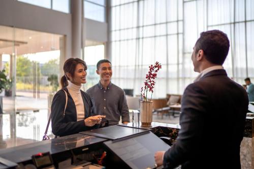 迪沙鲁Four Points by Sheraton Desaru的一群人围站在办公室的桌子旁