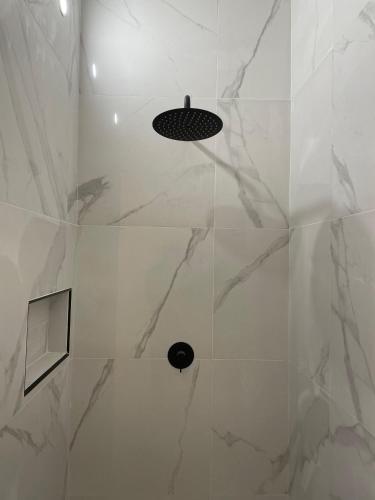 a bathroom with a shower with white marble walls at Marta's Sky in Marta