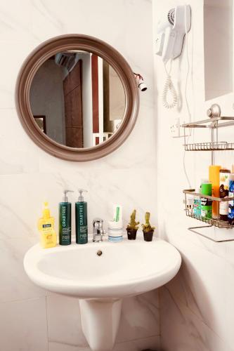 a bathroom with a white sink and a mirror at House of Sincerity in Maharagama