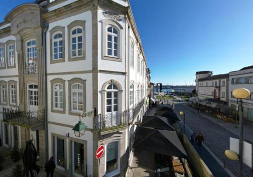 a building on a street with people walking in front of it at D'Avenida Apart in Viana do Castelo