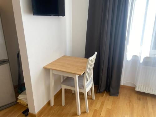 a wooden table and chair in a room with a window at Media harbor domicile in Düsseldorf