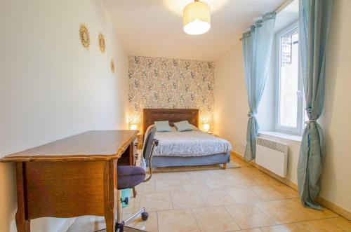 Un dormitorio con una cama y un escritorio. en La maison d'a cote, en Crancey