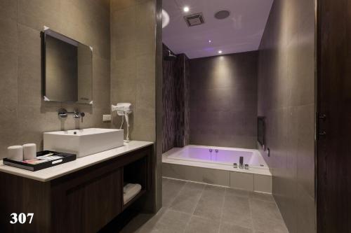 a bathroom with a bath tub and a sink at 520 Motel in Hsiao-hsin