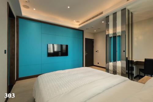 a bedroom with a large bed with a blue wall at 520 Motel in Hsiao-hsin