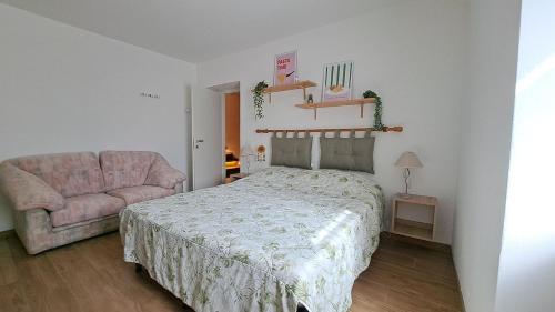 a bedroom with a bed and a pink couch at Apartment in Somaggia - CasaCamillo in Riva