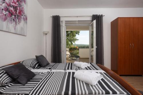 un grande letto con cuscini bianchi e neri di Holiday Home Lantina with pool a Pridraga
