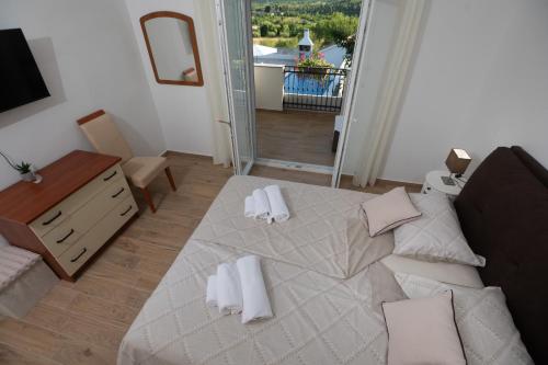 una camera da letto con un letto con cuscini bianchi e uno specchio di Holiday Home Lantina with pool a Pridraga