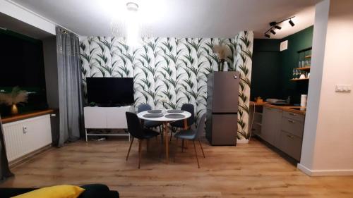 a kitchen and dining room with a table and chairs at Apartament w Sosnowym SPA in Serock