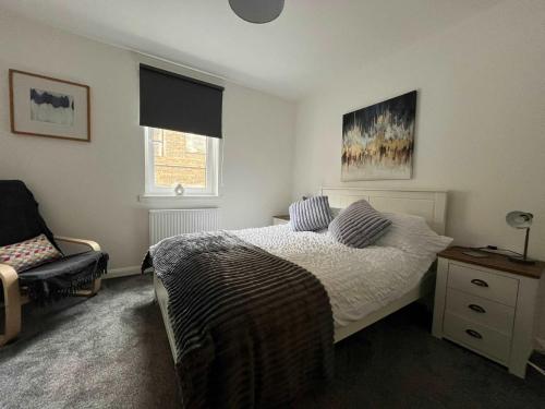 a bedroom with a bed and a chair at Albyn Retreat - Donnini Apartments in Prestwick