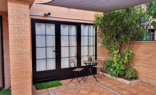 a patio with a black door and a table and chairs at Acogedor Apartamento Loft in Fuenlabrada