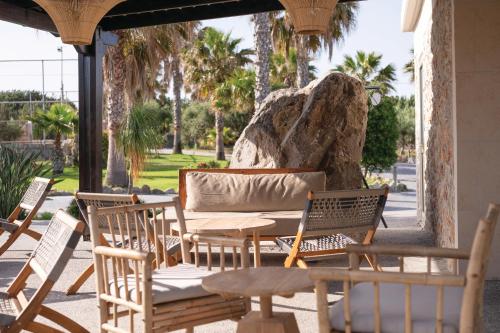 a wooden table and chairs on a patio at Achilleas Beach Hotel Adults Only in Mastichari