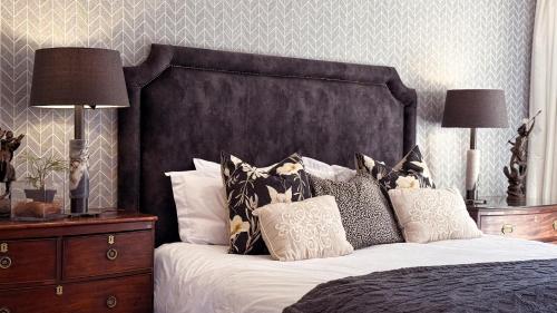 a bedroom with a large bed with pillows and two lamps at Upper Classic in Clarens