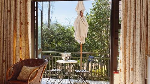 an open patio door with a table and an umbrella at Upper Classic in Clarens