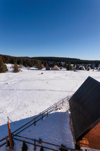a view of a snow covered field with a roof at Vila Oaza mira Golija in Golija