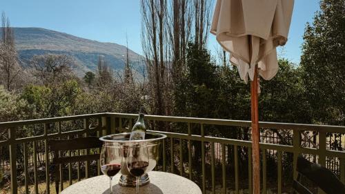a table with a glass of wine and an umbrella at Upper Classic in Clarens